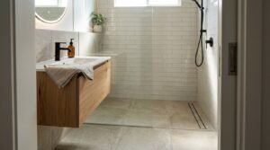 Curbless walk-in shower with linear drain, glass partition, and floating wood vanity in modern ADU bathroom